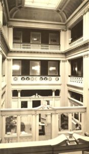 An early photo of the atrium when it was used as office space. The middle pony walls with their graceful broken cornices were later removed. Whitman Archives.