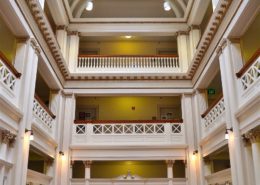 The restored atrium with its art glass skylight. Notice the turned balusters at the third level match those that replaced the solid wall of the proscenium in the former MacDowell Hall. Courtesy photo.