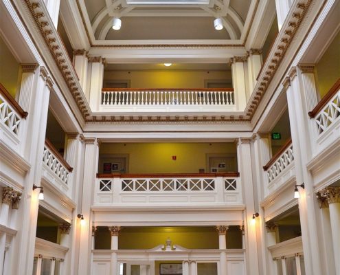The restored atrium with its art glass skylight. Notice the turned balusters at the third level match those that replaced the solid wall of the proscenium in the former MacDowell Hall. Courtesy photo.