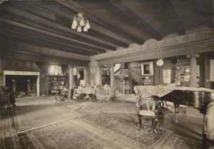 The grand living room with inglenook fireplace, left; entrance hall and staircase, right center; dining room, far right. Whitman Archives photo.